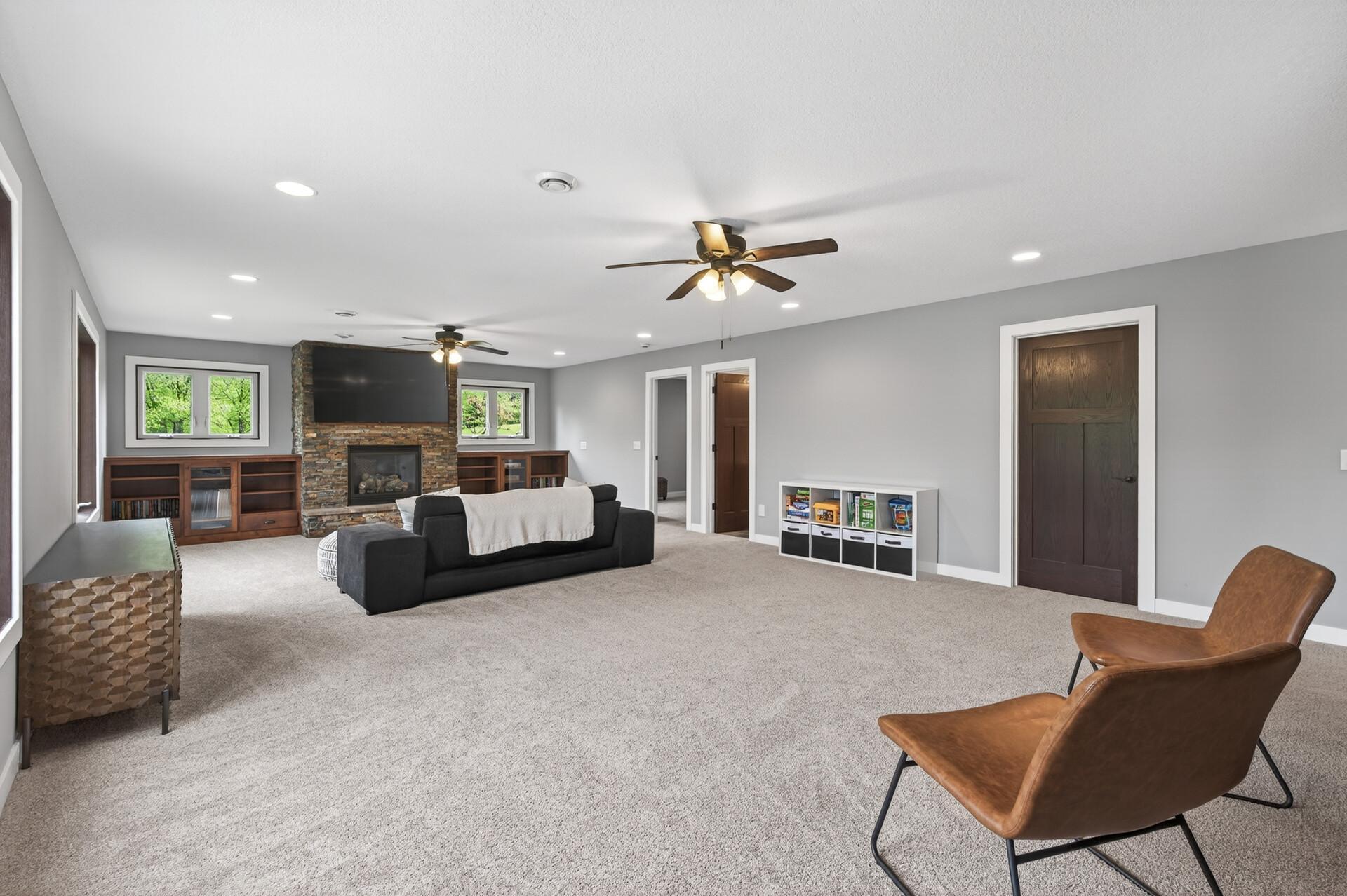 The expansive lower level great room boasts another fireplace, custom built ins and plenty of space.