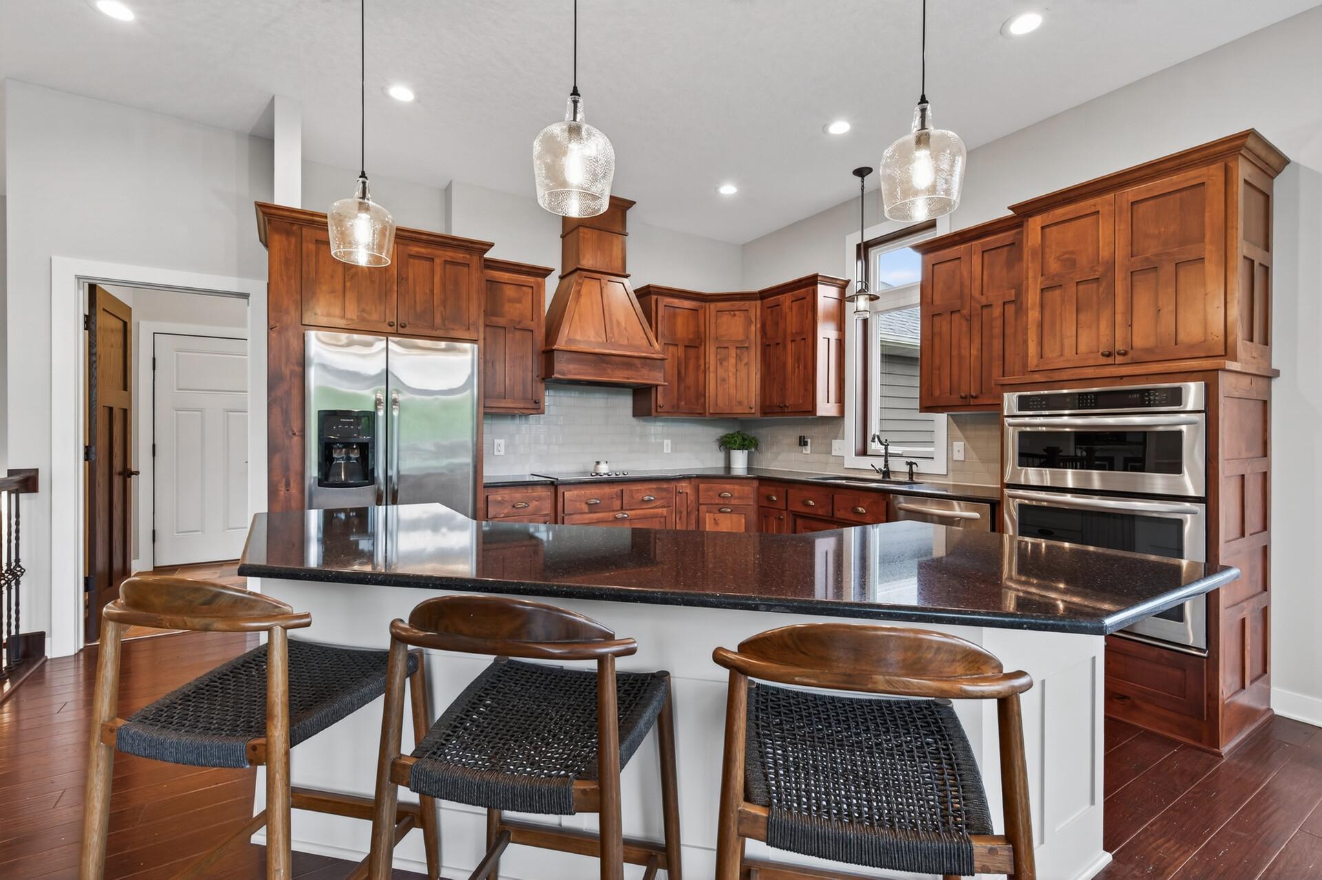 High end kitchen with stainless appliances, double oven, massive island, and granite counter tops.
