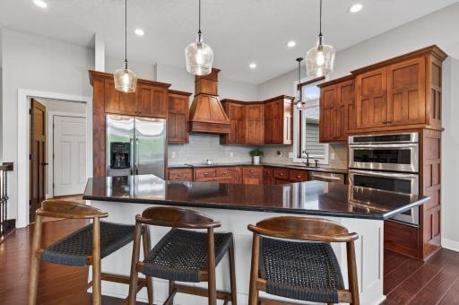 High end kitchen with stainless appliances, double oven, massive island, and granite counter tops.
