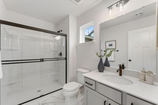 This stylish main level 3/4 bathroom complete with soft-close cabinets & drawers is conveniently located across the hall from the main floor bedroom!