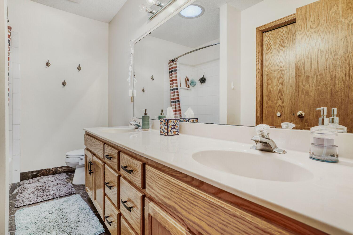 Upper-level full bath with double sinks.