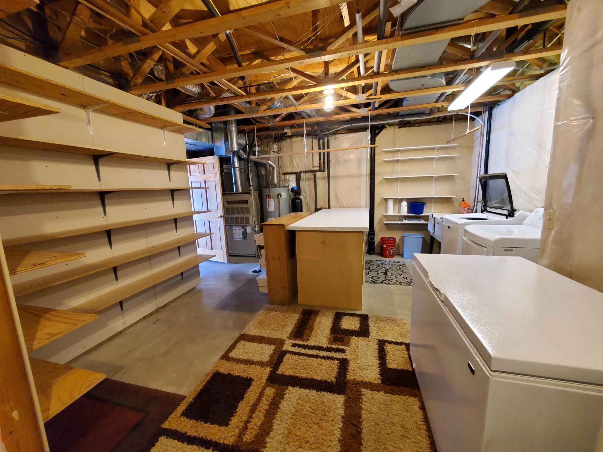 Lower-level laundry area. Counter space for all your folding needs, with plenty of shelf space as well.