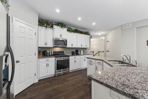 The kitchen offers crisp white cabinetry with abundant storage/prep space!