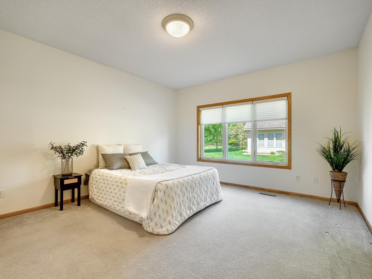 The primary bedroom is generous in size with neutral tones and abundant natural light.
