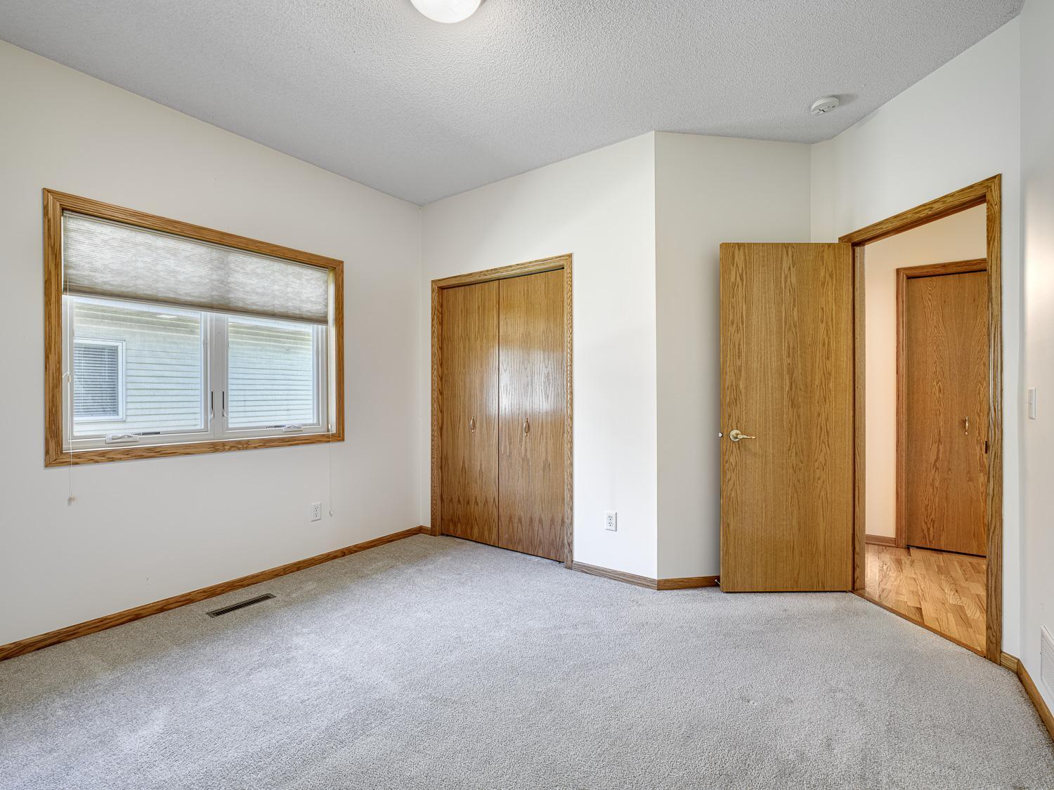 The second bedroom also features neutral paint and carpeting, offering a versatile and move-in ready space.