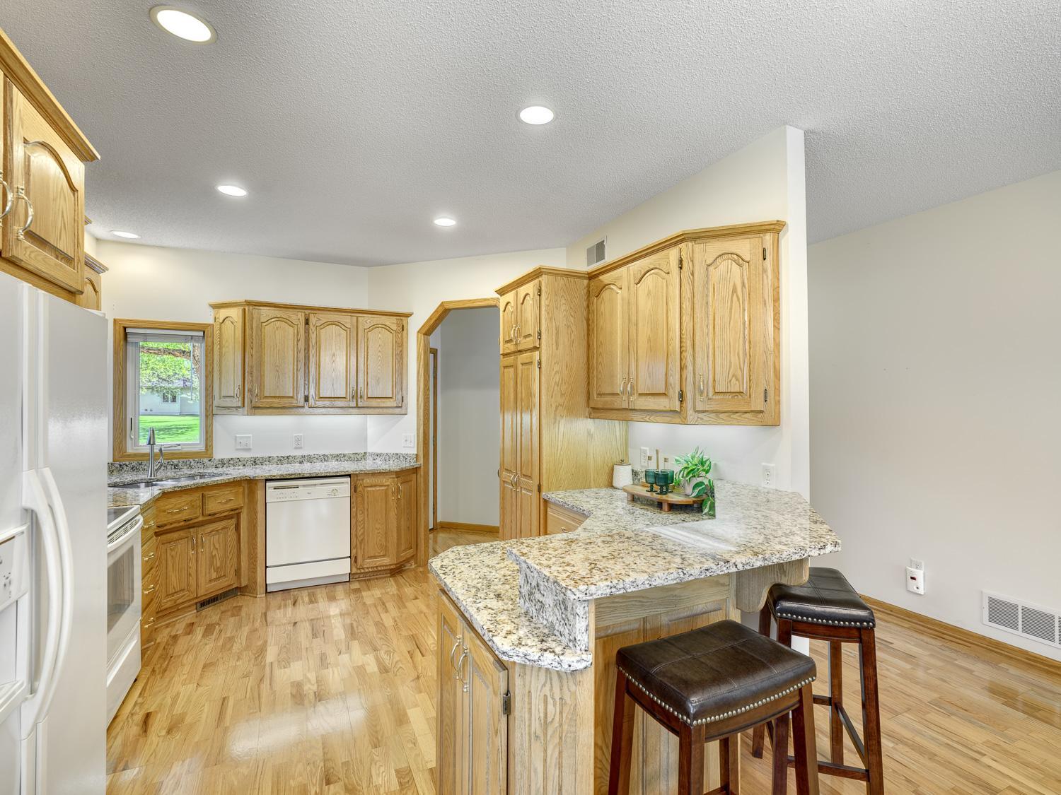 The kitchen boasts rich wooden cabinetry with abundant storage/prep space!
