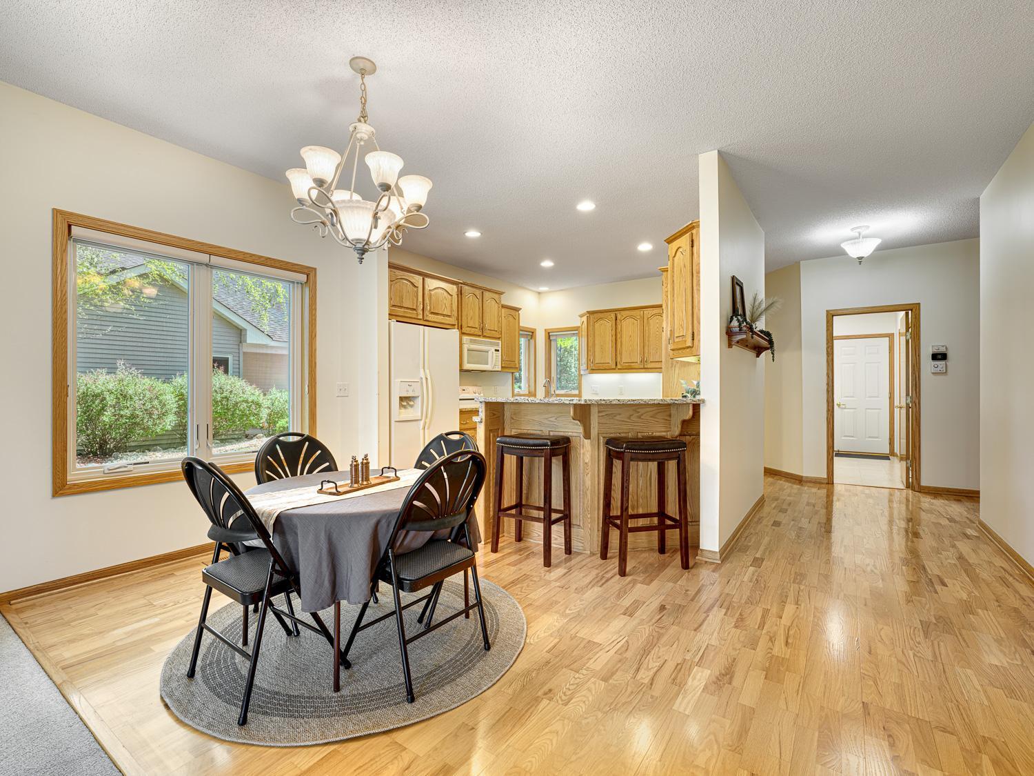 Gleaming hardwood floors flow throughout the entry, hallway, kitchen, and dining room for a seamless look.