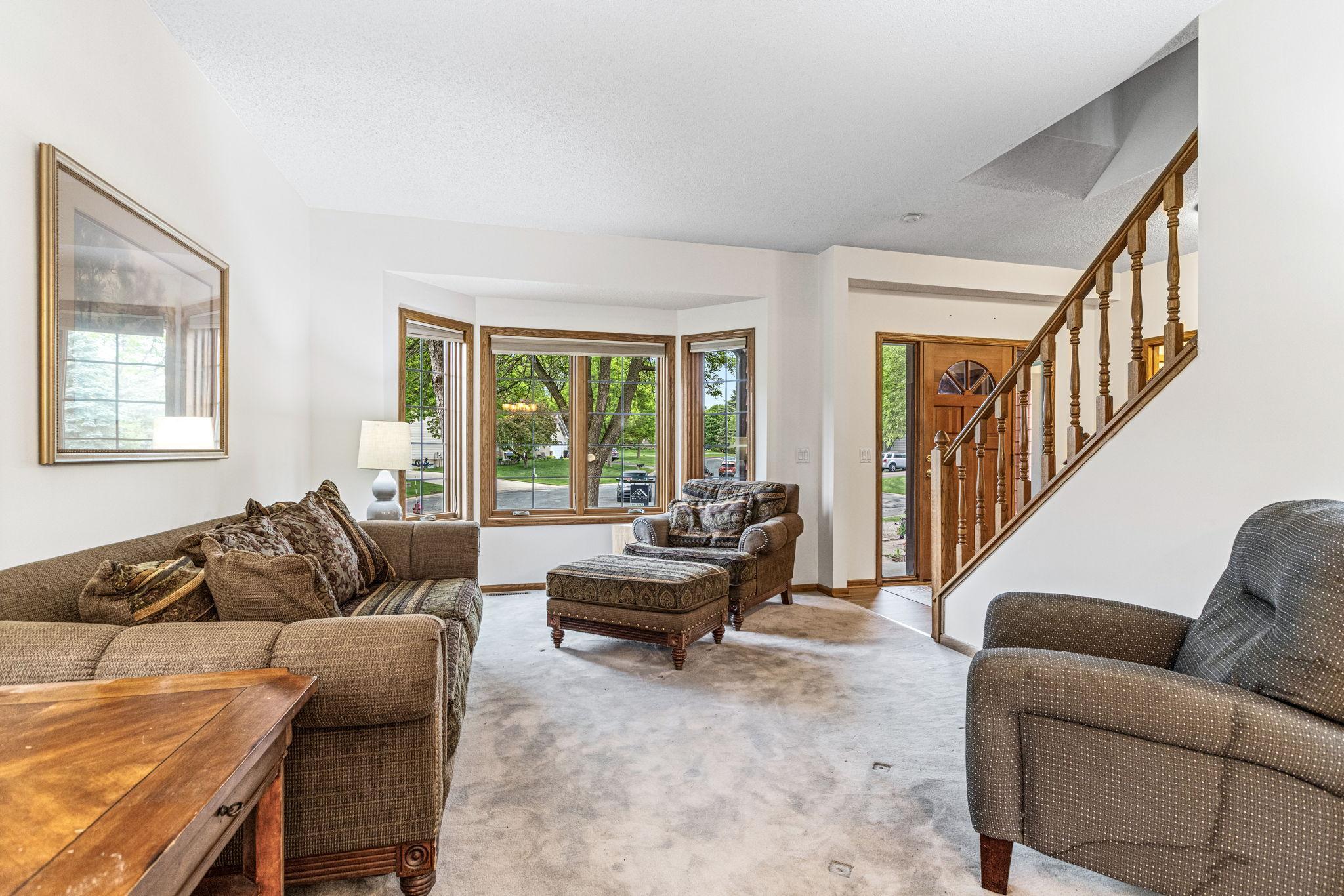 Living room with bay window and oak staircase