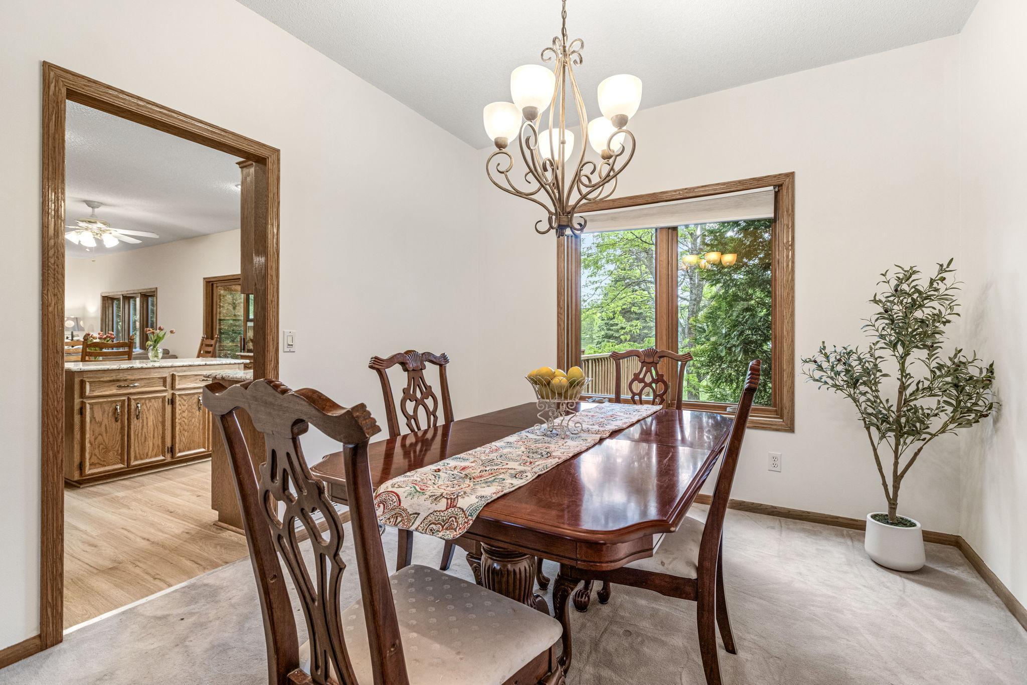 Formal dining room with chandelier and window overlooking the backyard