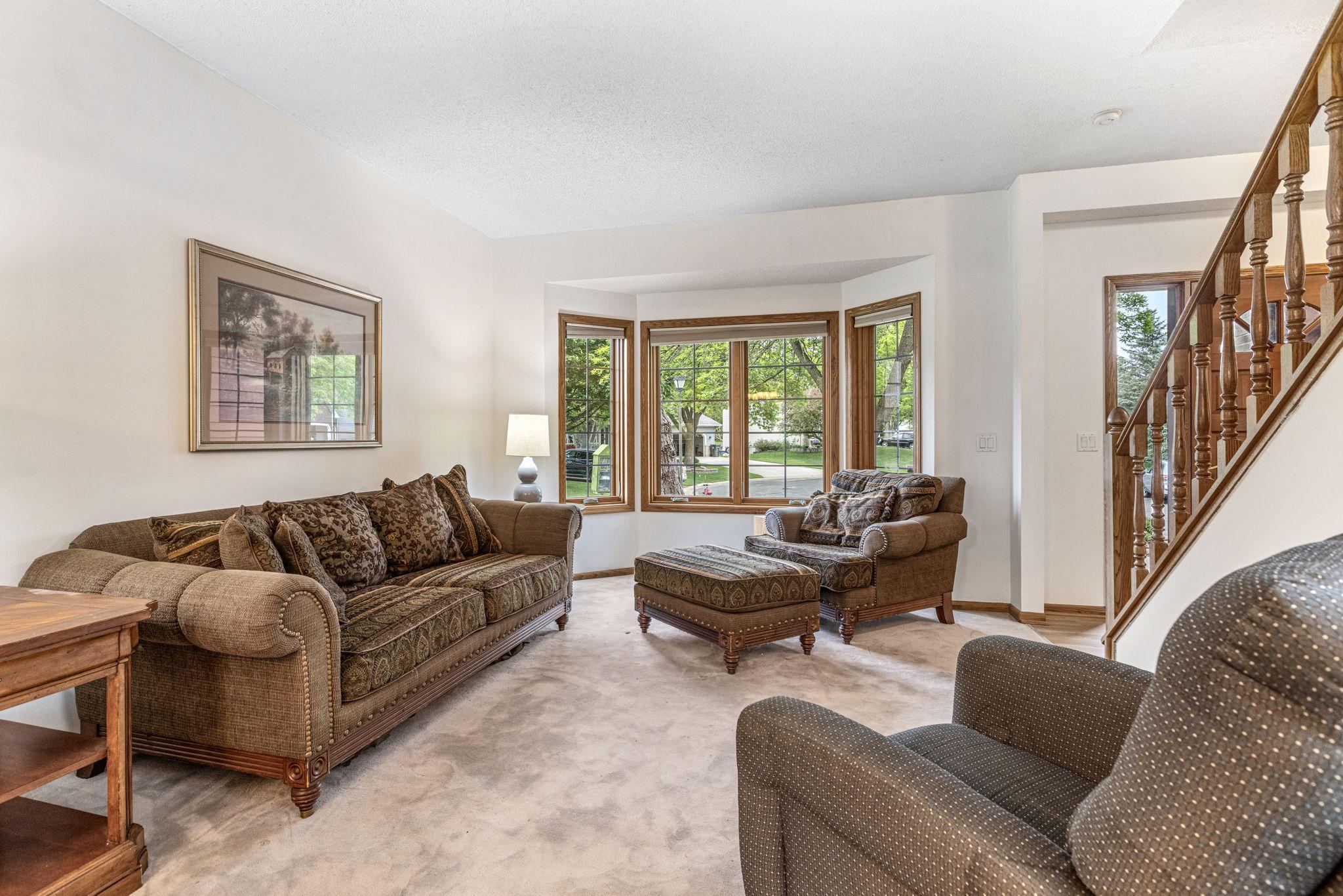 Another view of the living room with large bay window and neutral tones