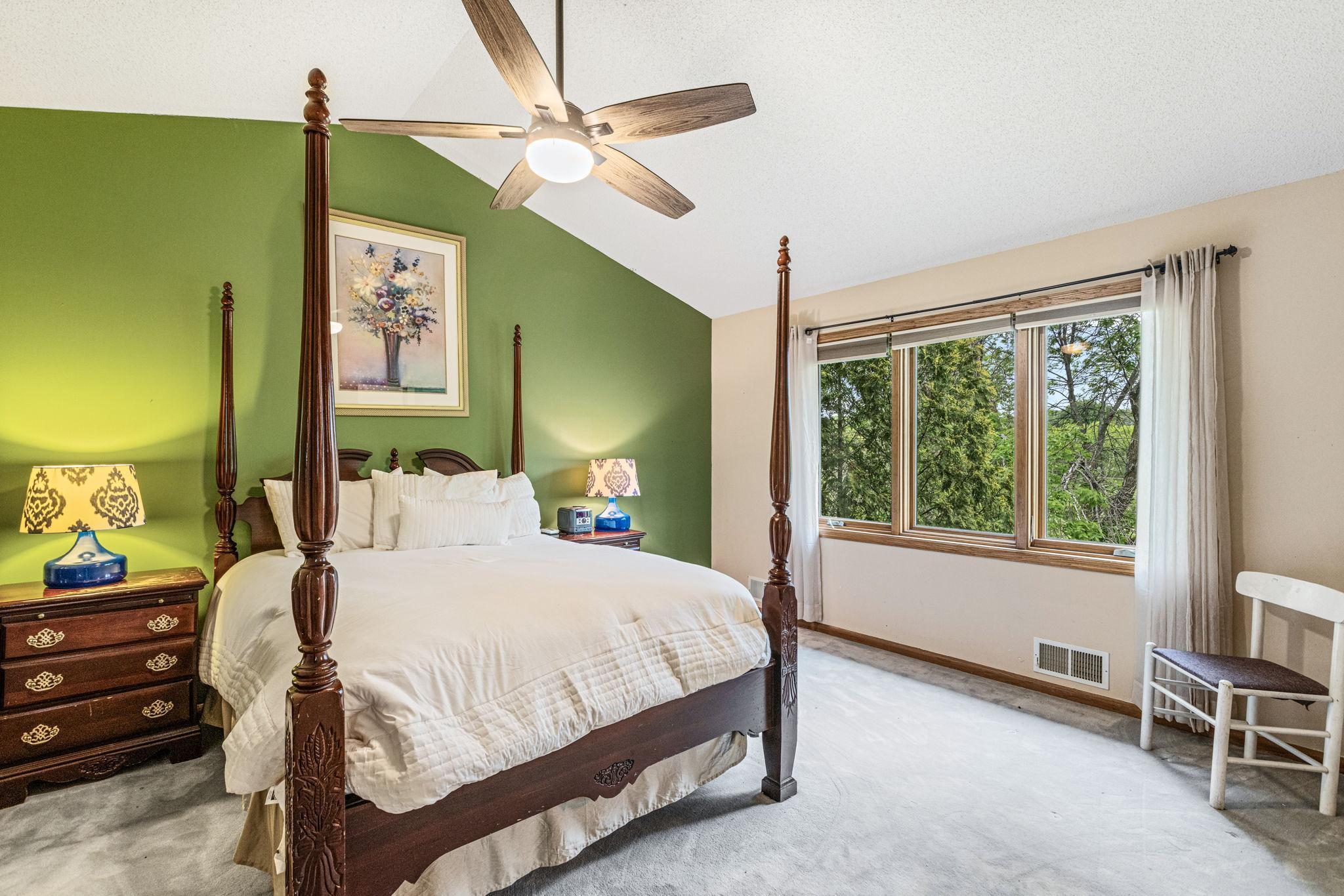 Primary bedroom with vaulted ceiling and looking out to the backyard