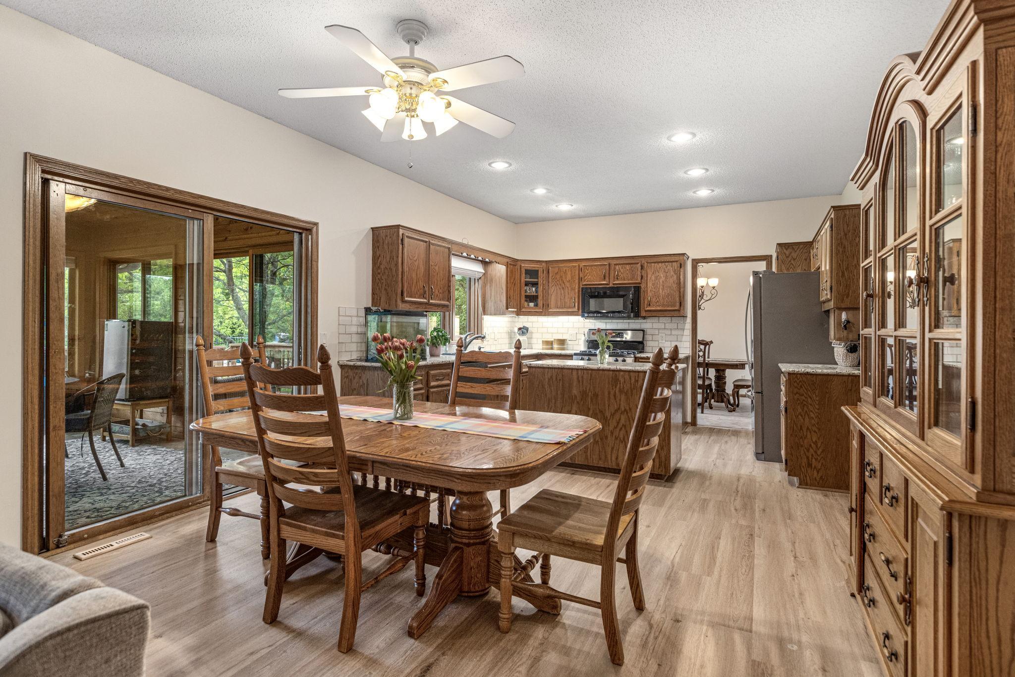 Casual dining space with vinyl plank floors and open kitchen view.