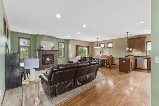 Open floor plan with a gas fireplace and upgraded kitchen. Across from the back of the nearest couch is access to the generously sized mudroom.