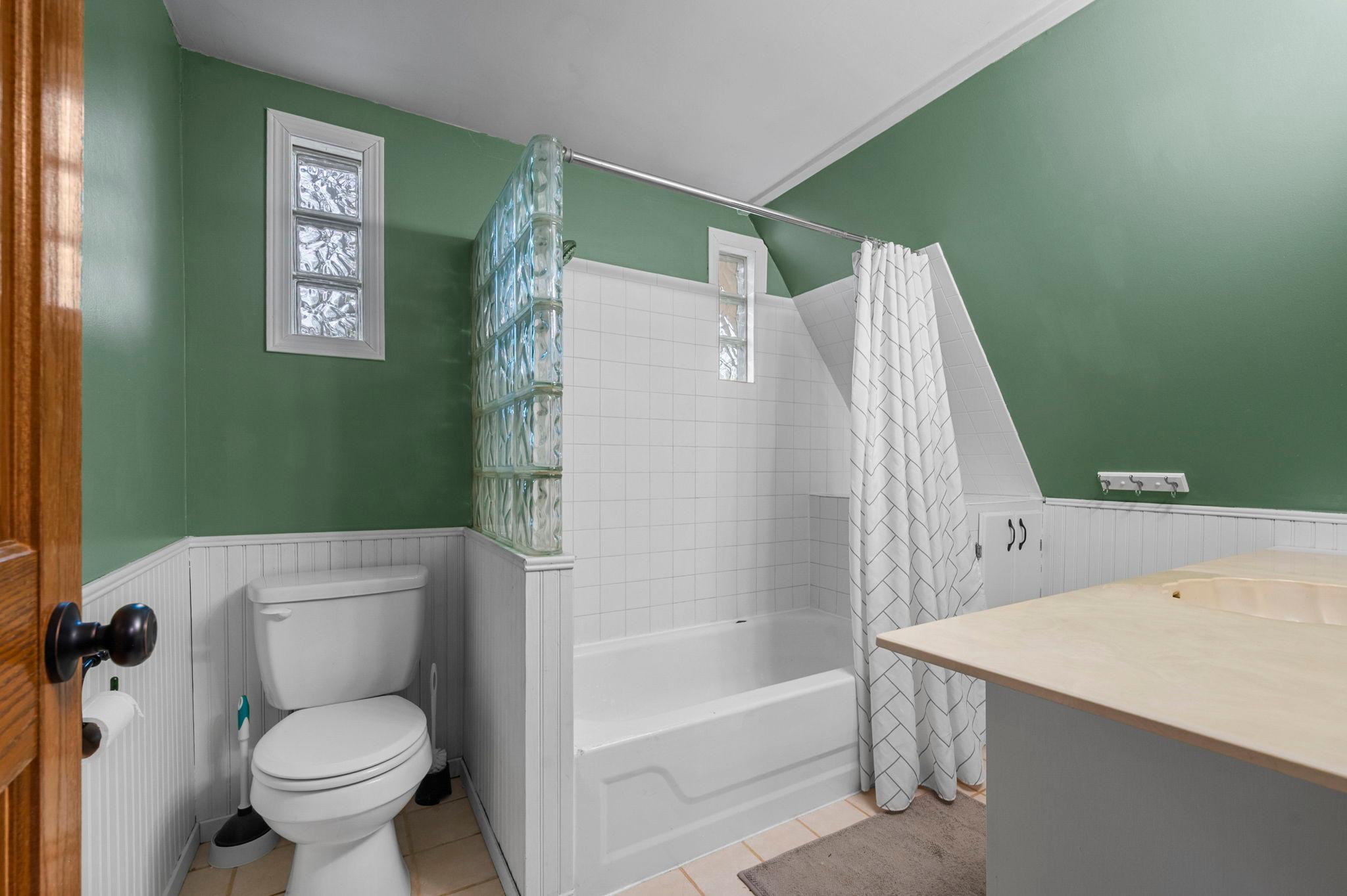 Upstairs full bath blends historic charm with modern convenience.