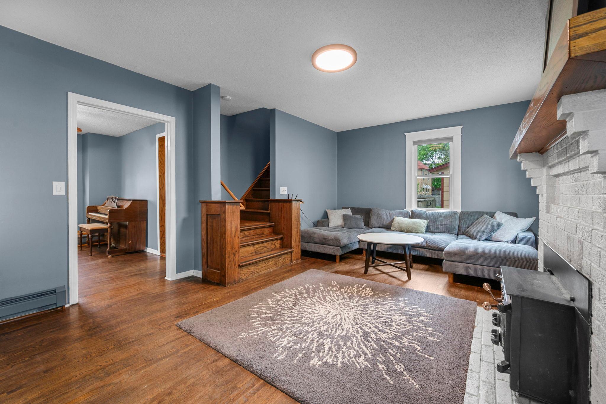 Spacious living room features stunning hardwood floors, tons of natural light, and a beautiful brick fireplace.