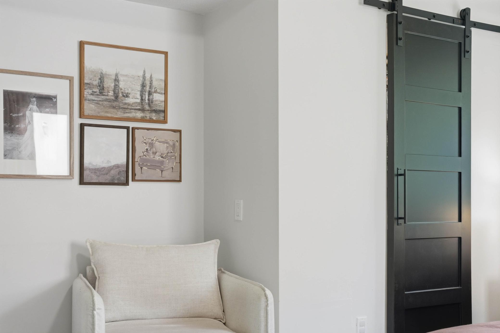 Sitting nook in primary bedroom with barn door to the first of two closets