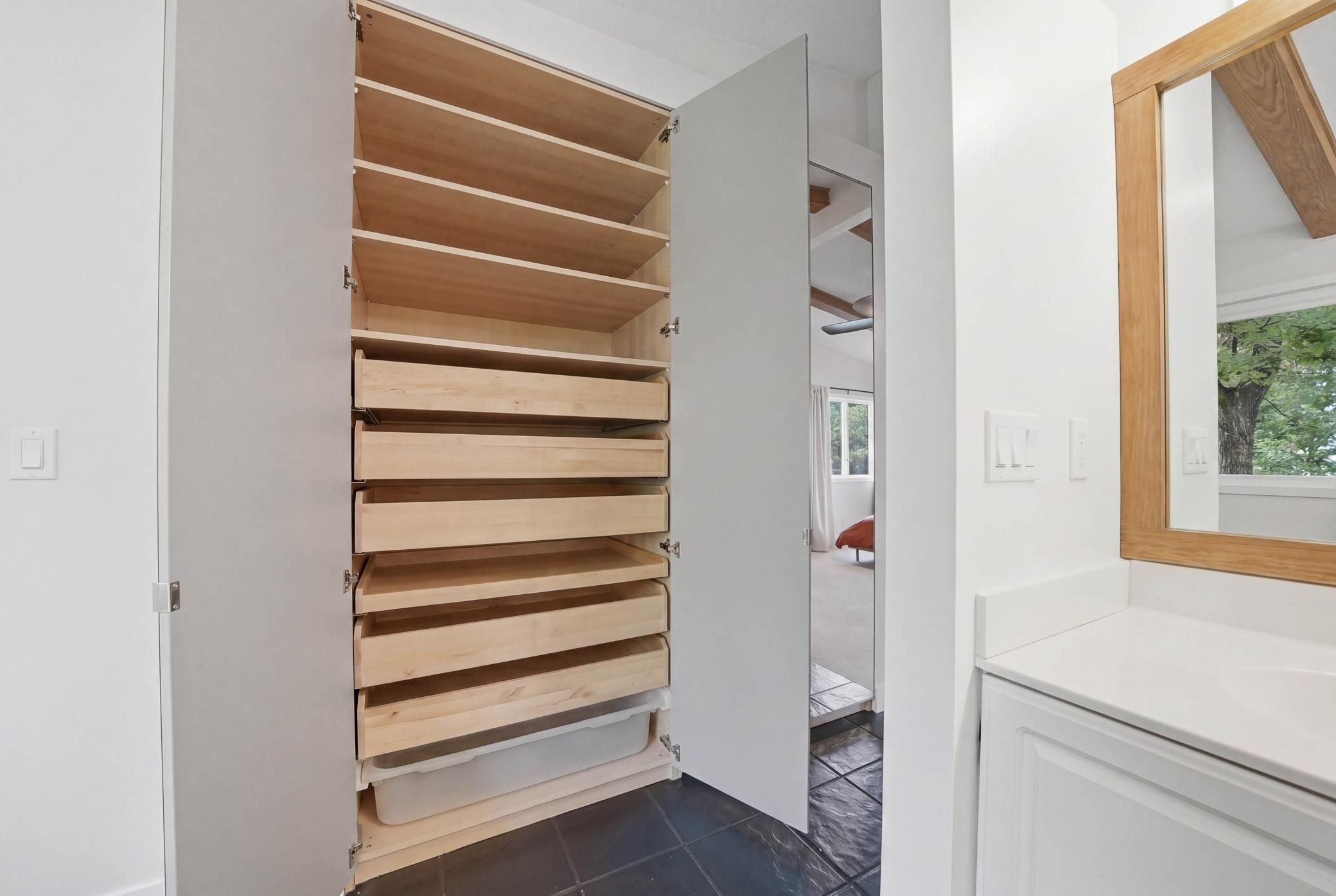 Open the mirror to reveal a huge built in closet organizer