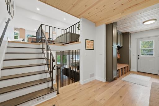 Inviting first impression and newly built mudroom with custom cabinetry.