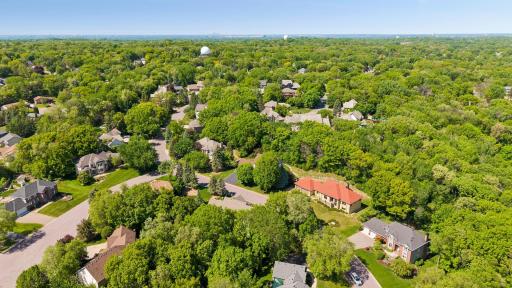 Birds eye view of neighborhood. This home is hiding just behind the beautiful hardwood trees to the left of the home with the red roof.