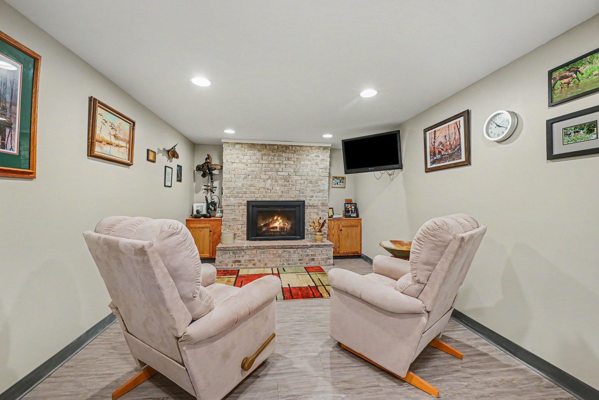 The lower-level amusement room is anchored by a gas fireplace on one side and offers plenty of space for table tennis, a game table, and exceptional storage on the other. The room dimension is 10 x 37.