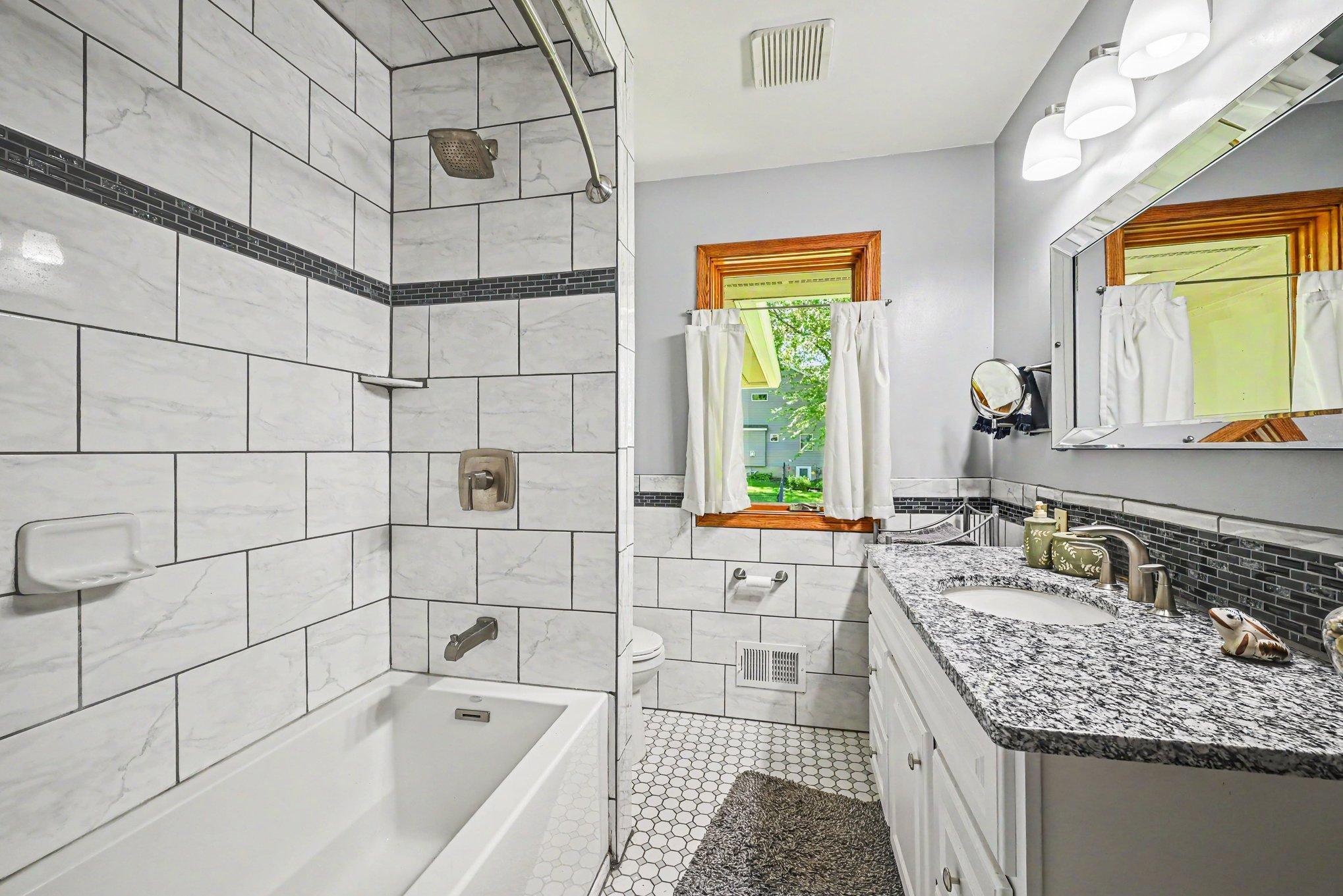 A large custom tiled main level bathroom with a soaker tub.