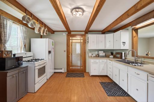 Nice size kitchen complete with pergo style flooring, white cabinets & lovely beamed ceiling.