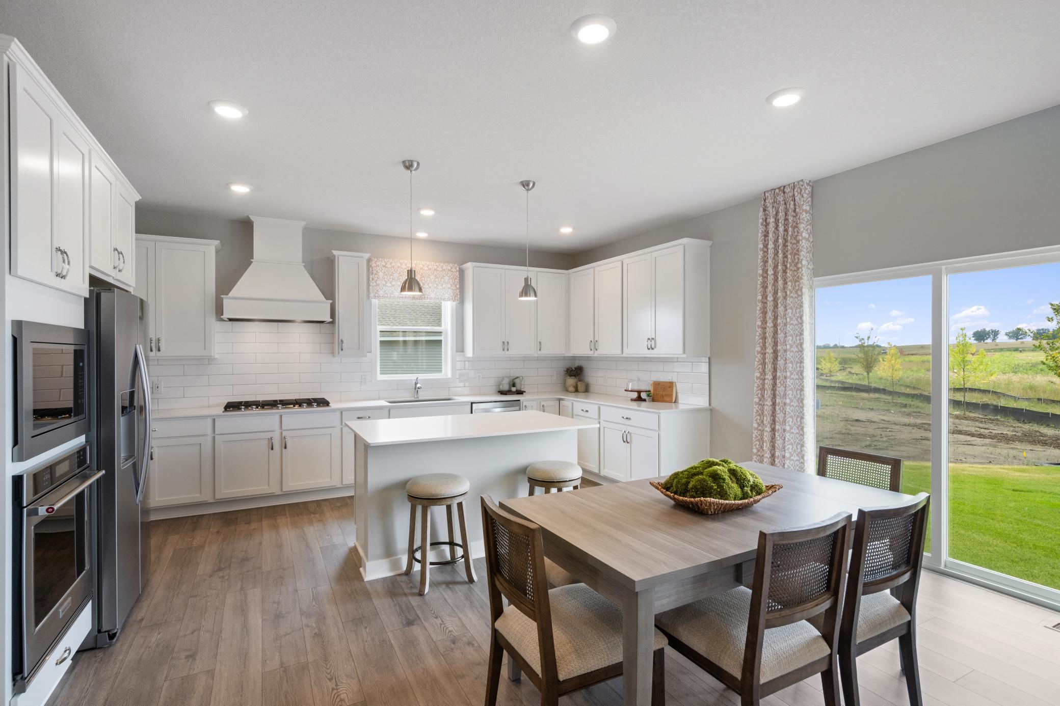 Light and bright kitchen with lots of counter space. Photo of prior model home, colors and finishes will vary.