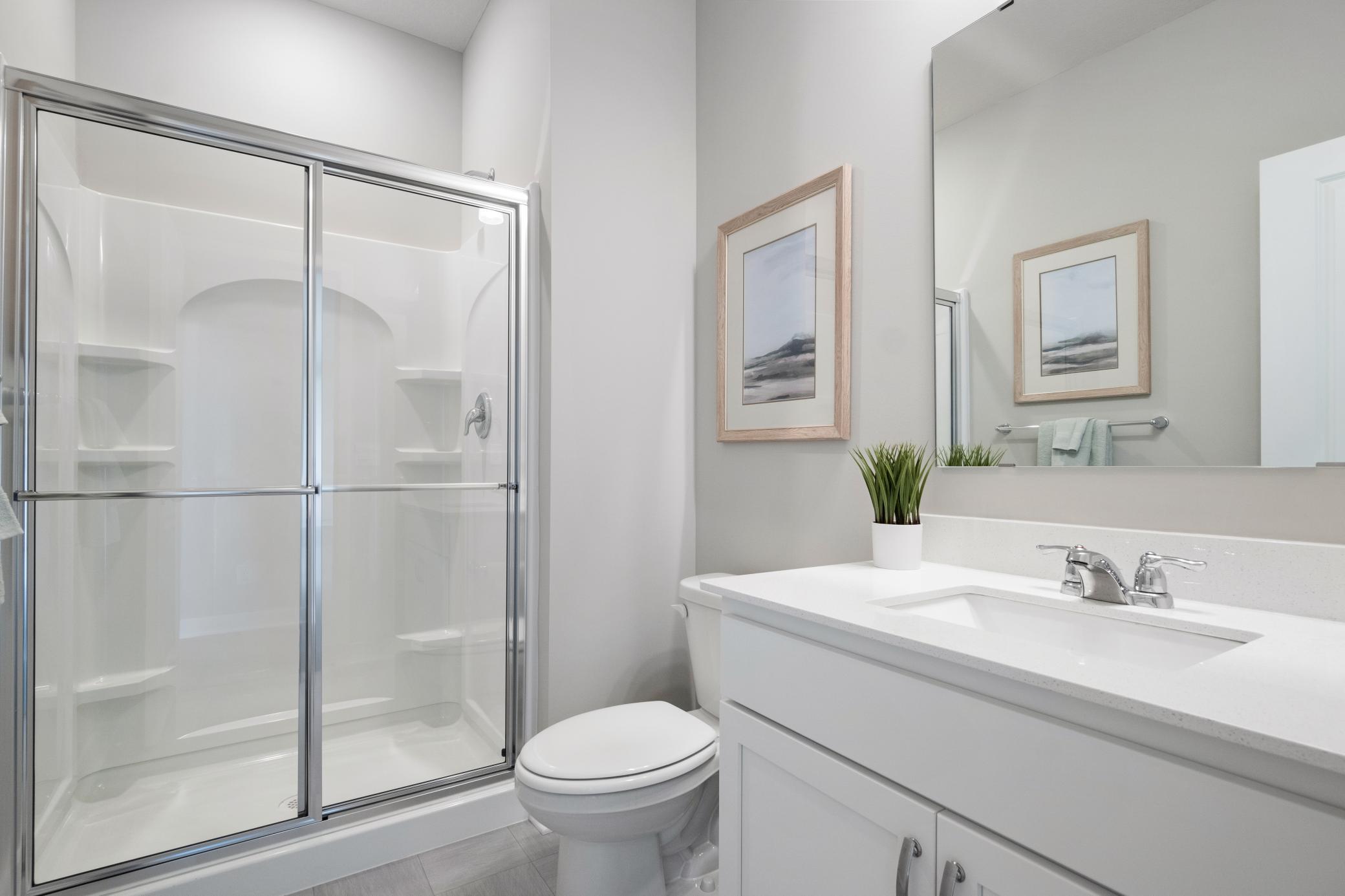 Main floor ensuite bathroom. Photo of prior model home, colors and finishes will vary.
