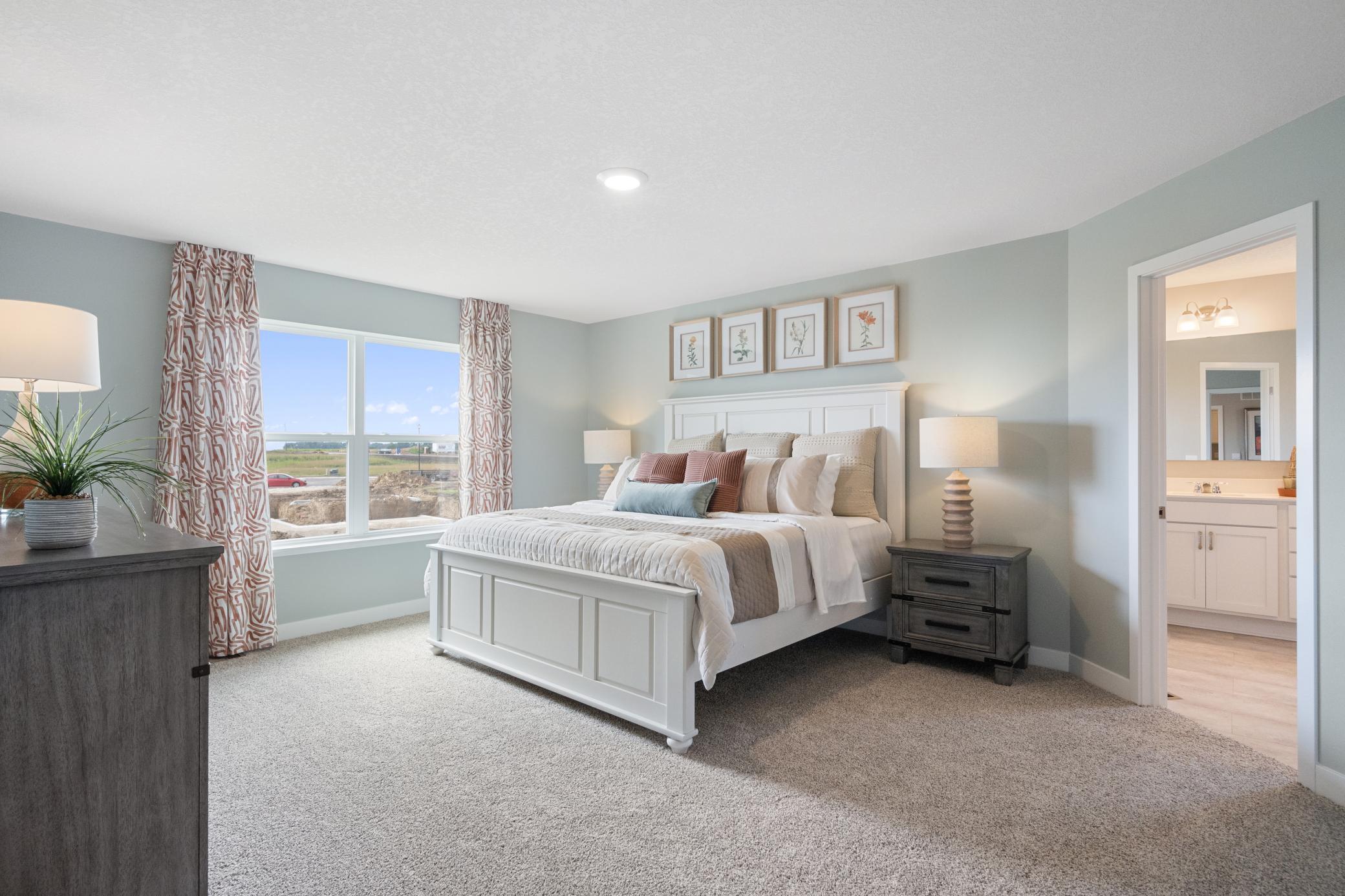Primary bedroom is spacious yet cozy. Photo of prior model home, colors and finishes will vary.