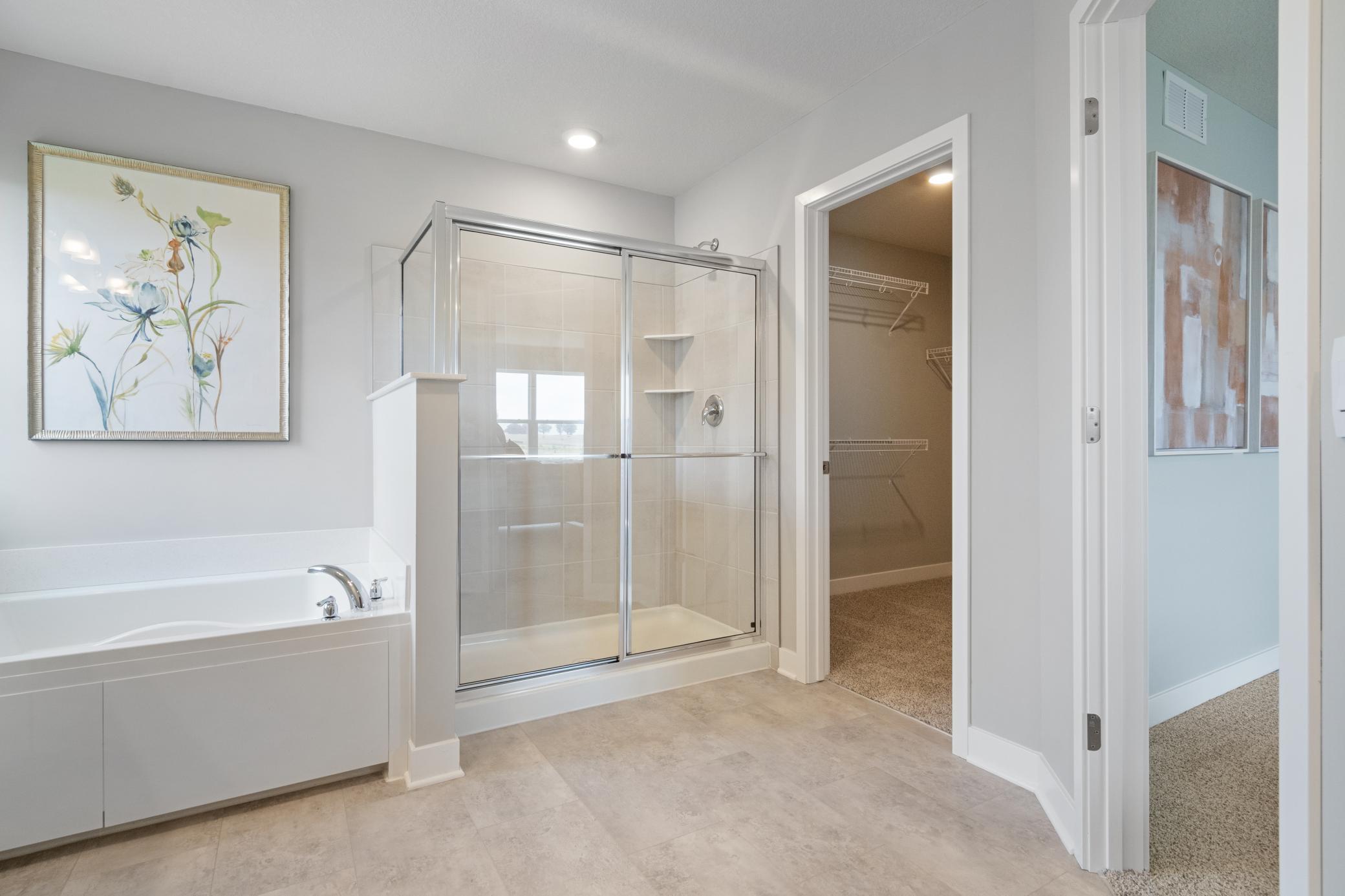 Primary Bathroom with soaking tub and separate shower. Photo of prior model home, colors and finishes will vary.