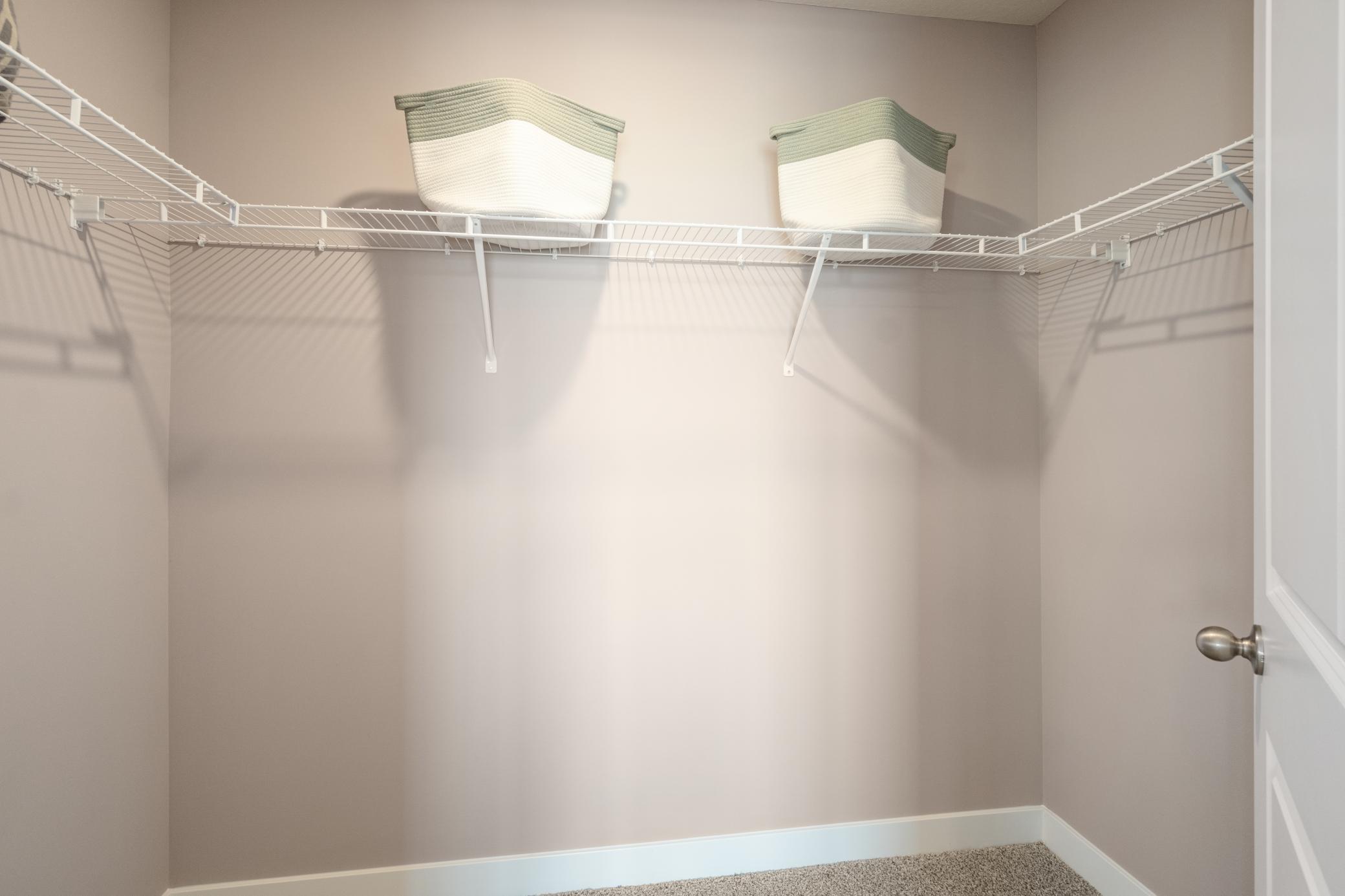 Primary bedroom offers TWO walk in closets. No need to share! Photo of prior model home, colors and finishes will vary.