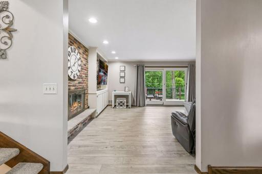 From the entry there are stairs that lead to the upper and lower levels and you can see into the living room and deck beyond.