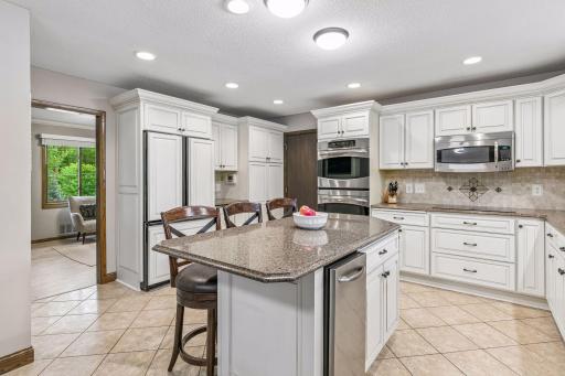 And stainless steel appliances including a double oven w/ convection baking, an electric cooktop, microwave, trash compacter and dishwasher. The built-in refrigerator blends in seamlessly with the cabinetry.