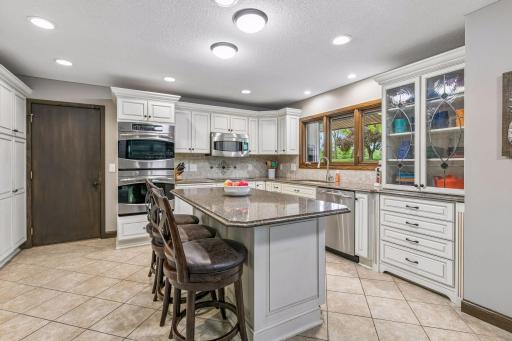 The updated kitchen has an ample cabinet space including an island and the decorative glass front cabinet which is practically located near the dishwasher.