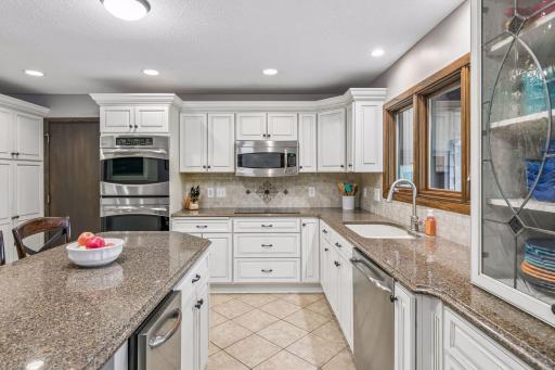 There are quartz counters with a tile backsplash.