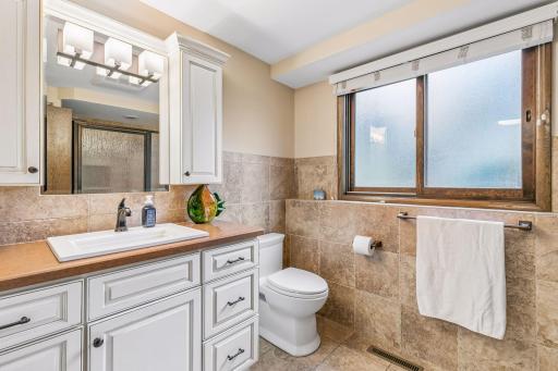 The lower level bathroom has a quartz vanity, ceramic wall and floor tile as well as a tile shower. There is a linen closet as well.
