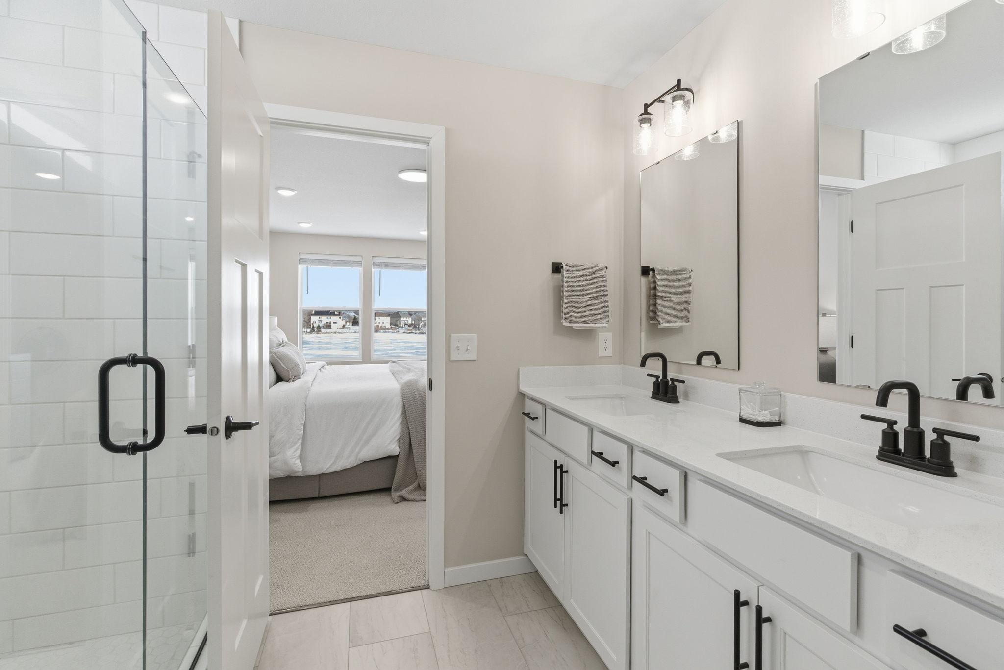 A walk-in subway tiled shower with frameless glass delivers a clean, elevated aesthetic. Thoughtfully designed with crisp finishes and serene tones, this private retreat blends everyday function with upscale elegance.