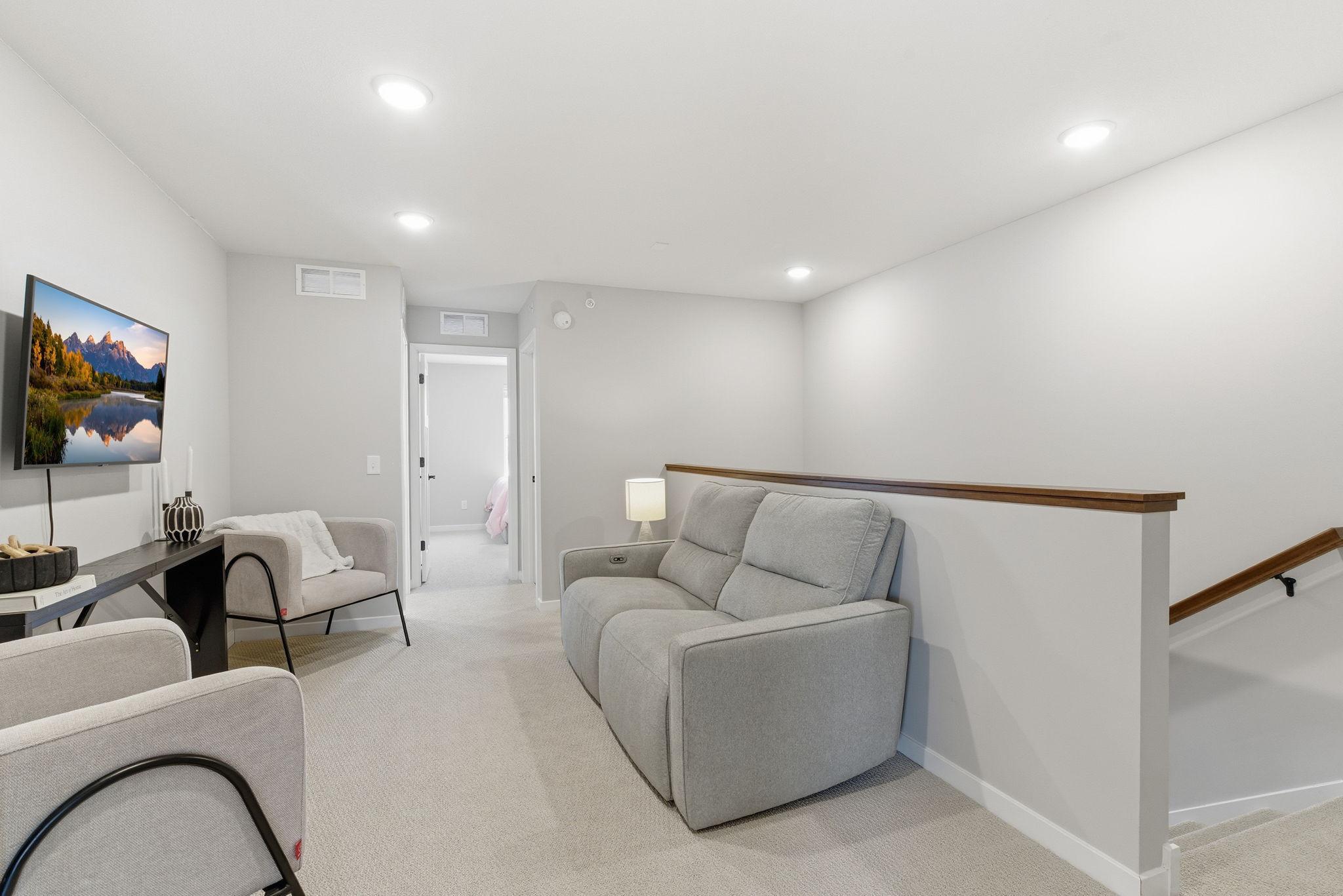 A flexible upper-level family space anchors the bedroom wing, offering direct access to the bedrooms along with a full bath—perfect for movie nights, a kids’ lounge, or a quiet reading area.
