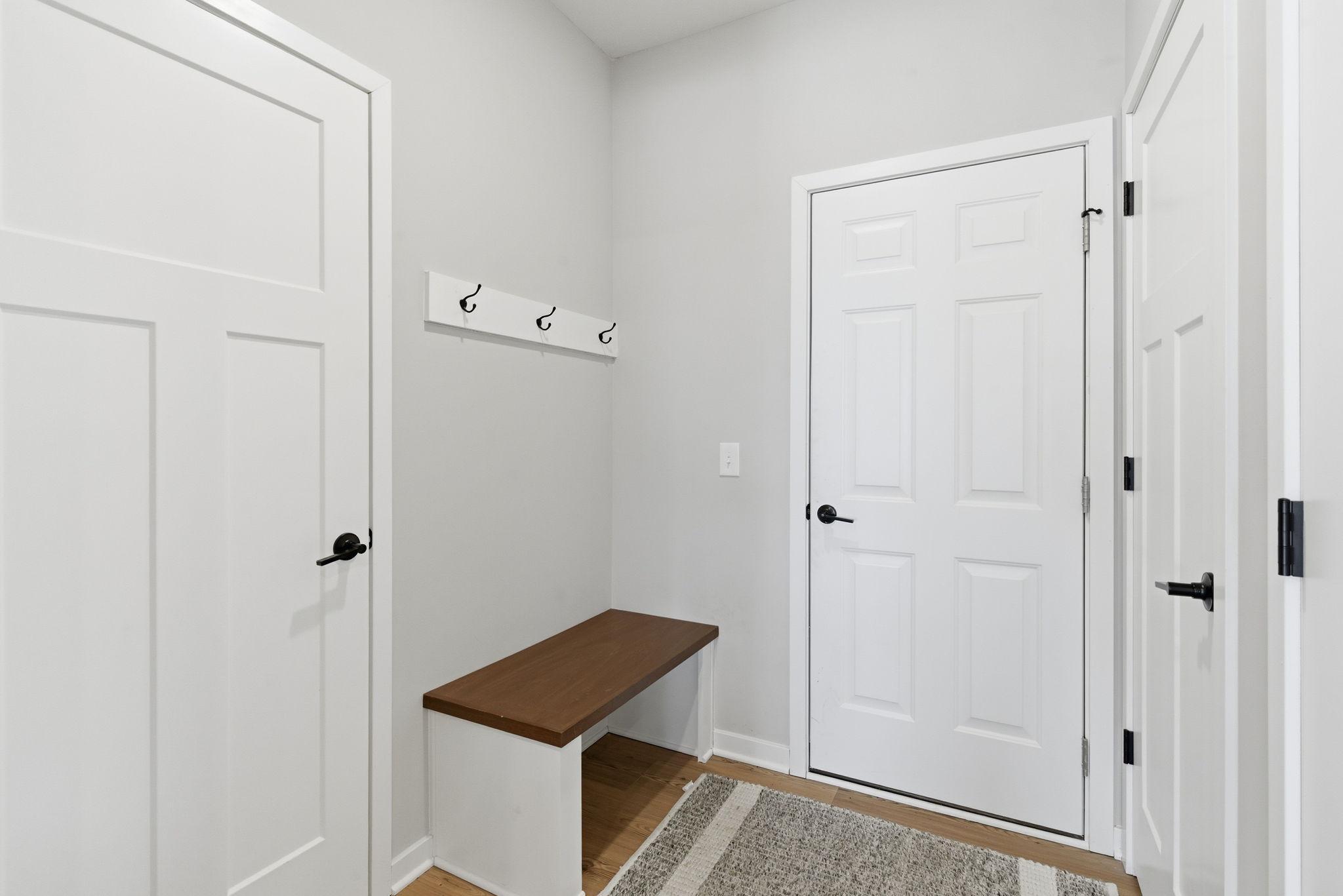 Just off the garage, a functional drop zone welcomes you with a built-in bench & hooks—perfect for everyday organization. This space offers convenient access to a closet & kitchen pantry, creating an efficient transition into the heart of the home.