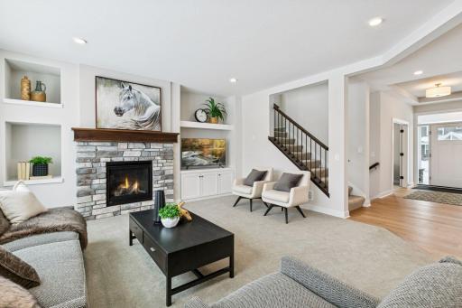 The living room on the main floor has a beautiful gas fireplace and wall built-ins. (Photo of a previously built Summit Floorplan)