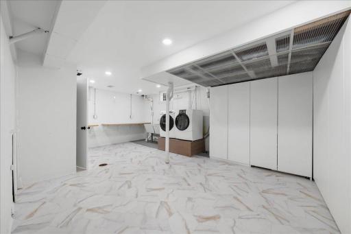 Huge laundry room with tons of additional storage, Large laundry tub sinks, Counter tops for folding clothes and door leading to lower level 3/4 bathroom