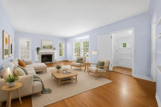 View of the entrance to the home including expansive Living Room featuring Cove ceiling, beautiful oak hardwood floors, and wood burning fireplace - Virtually Staged Image!