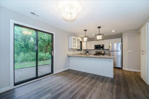 Dining room walks out to paver patio and wooded treeline.