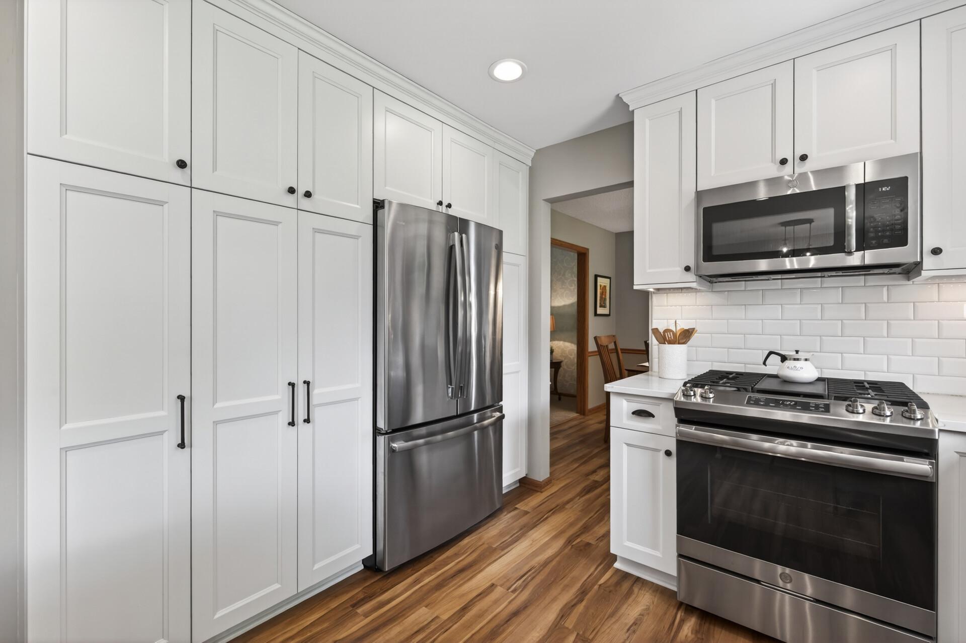 Nothing is lacking in the kitchen with a gourmet gas range with overhead microwave, French door refrigerator and this full wall pantry system