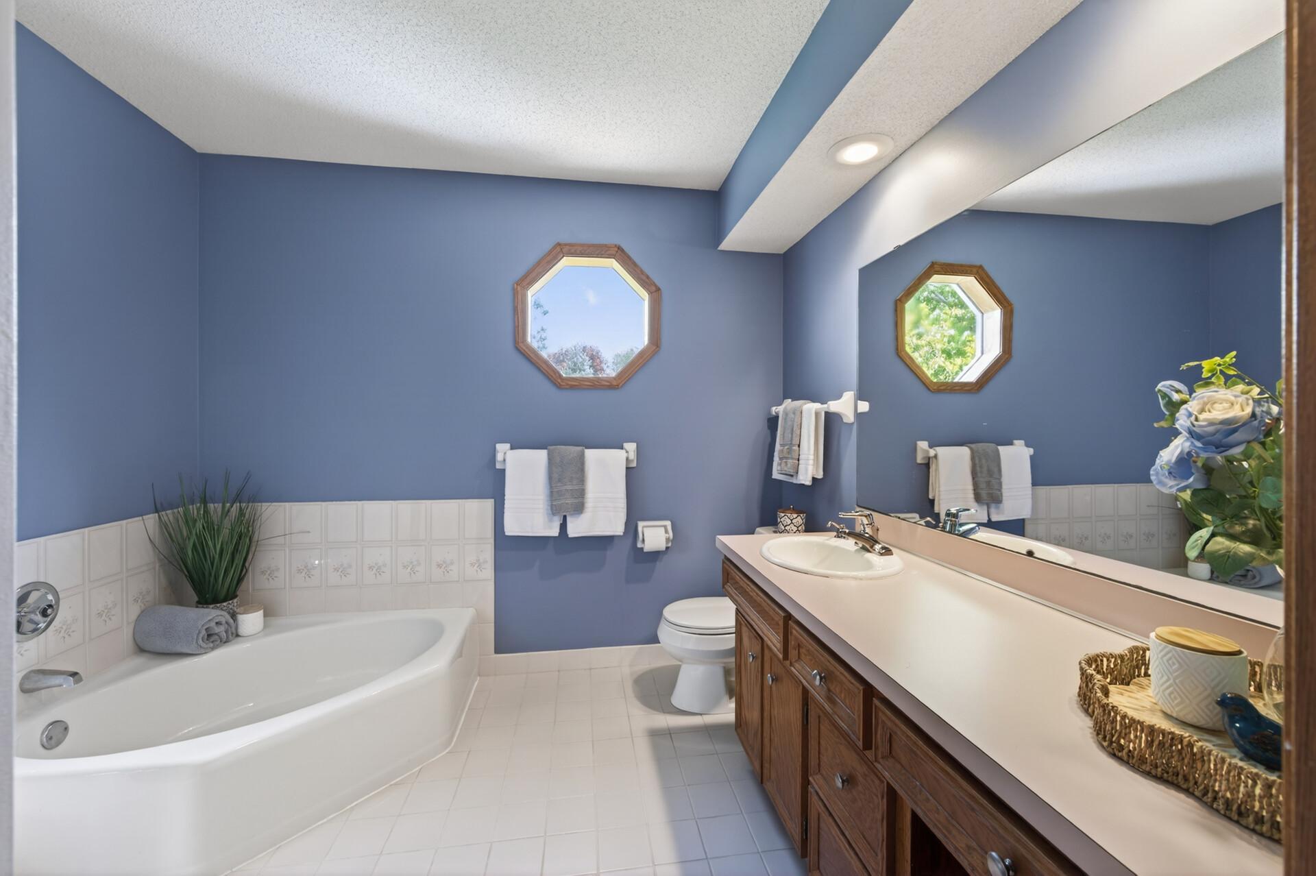 The upper level shares this huge 4 piece full bath with corner tub, large vanity with full size mirror and cute porthole window