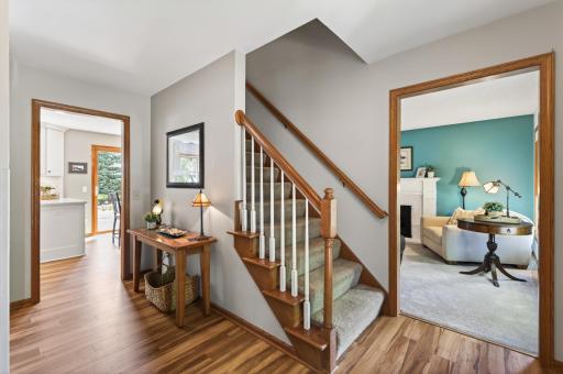 Step inside to this bright and inviting foyer with warm woodwork, durable flooring, and views into multiple living spaces