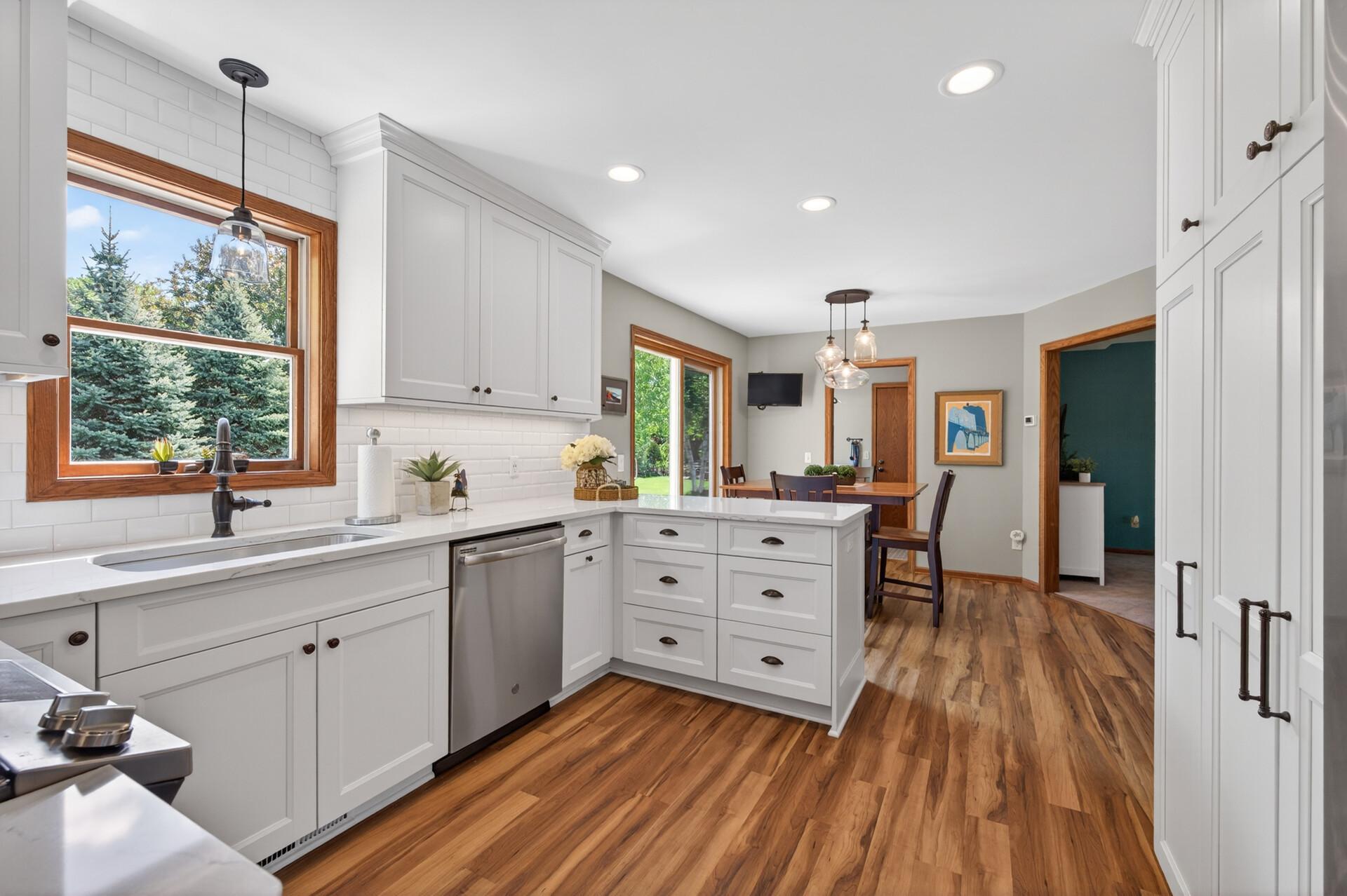 Gorgeously updated kitchen showcasing stainless appliances, stone counters, custom cabinets and updated lighting and fixtures
