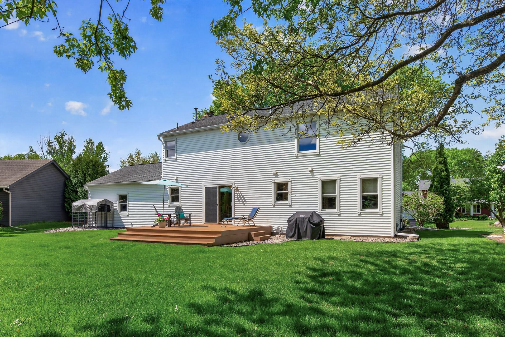 Spacious backyard retreat featuring a large deck, mature shade trees, and exceptional privacy.
