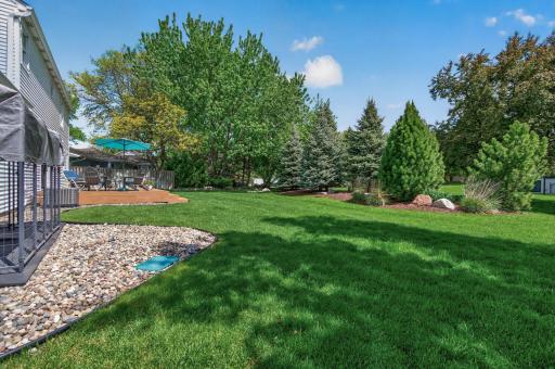 Serene backyard setting with bermed plantings, manicured landscaping and plenty of room to play or entertain.