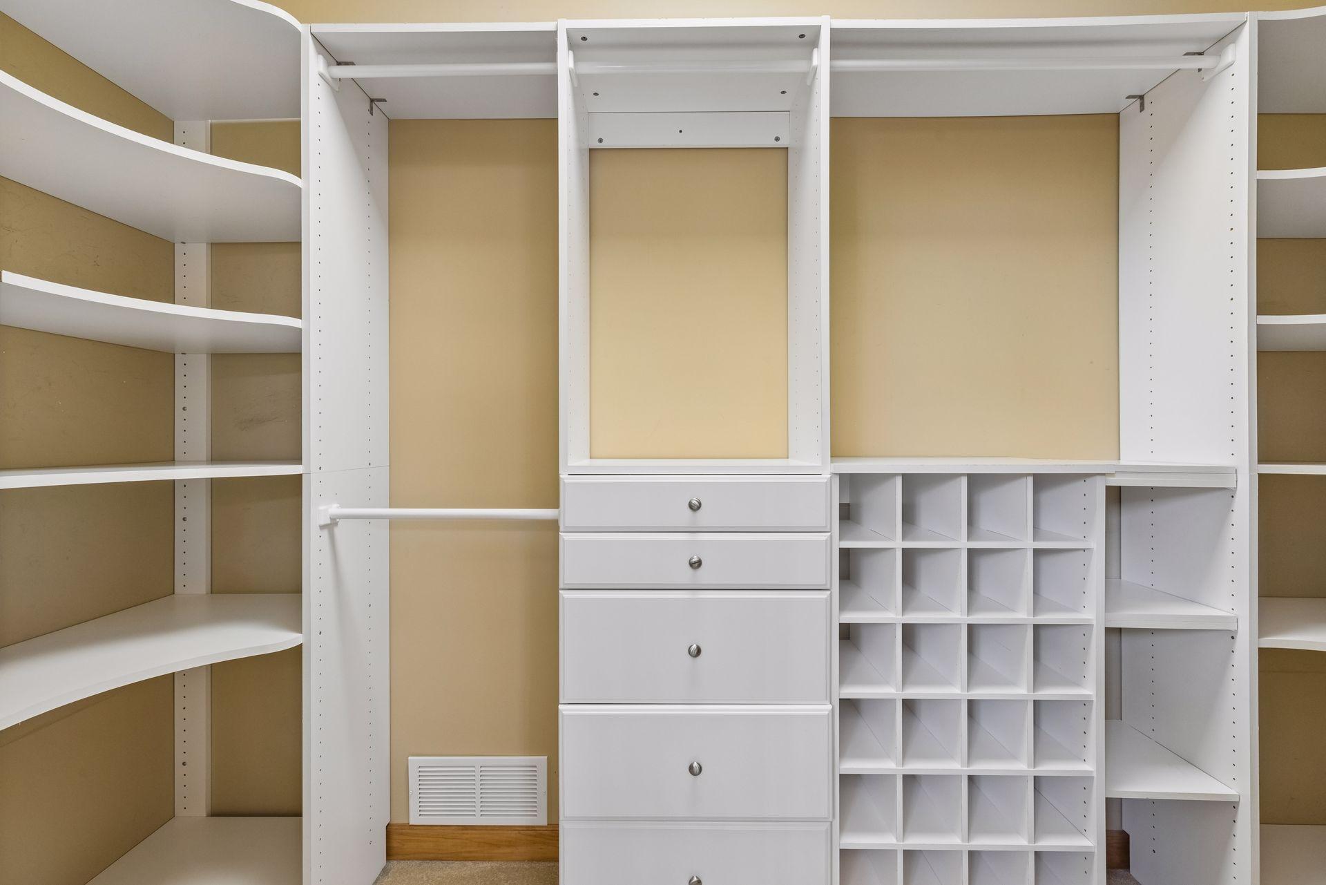 Large primary bedroom custom walk-in closet with organization system.